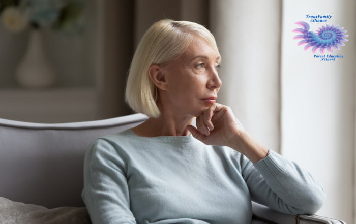 Parent of a trans kid staring contemplatively out of a window