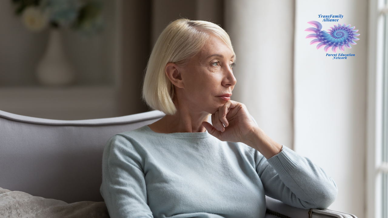 Parent of a trans kid staring contemplatively out of a window