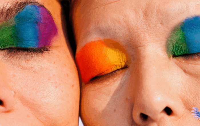 Close up of two older people with Pride makeup celebrating their intimacy and community during Pride Month