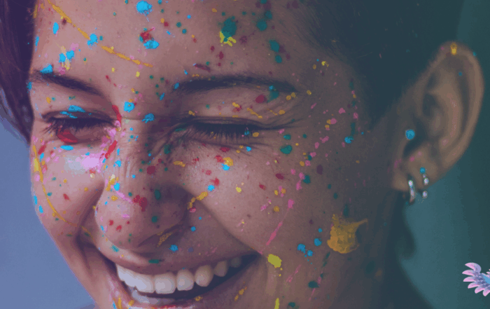 Close-up portrait of a rans or gender-diverse person covered in paint and confetti, celebrating their authenticity