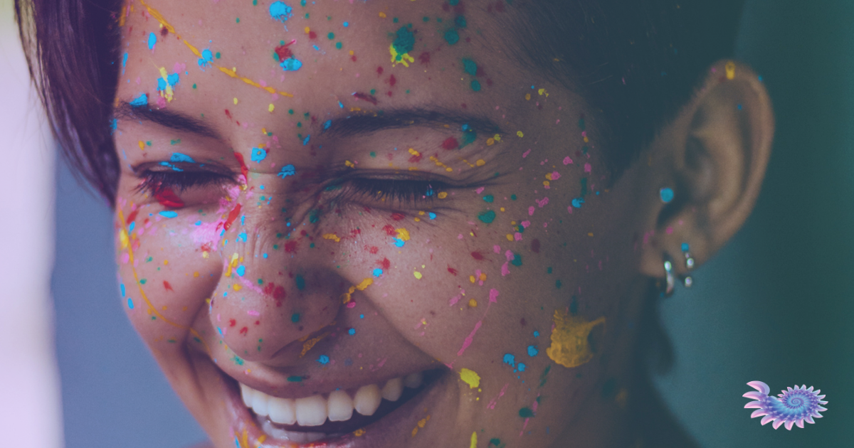 Close-up portrait of a rans or gender-diverse person covered in paint and confetti, celebrating their authenticity