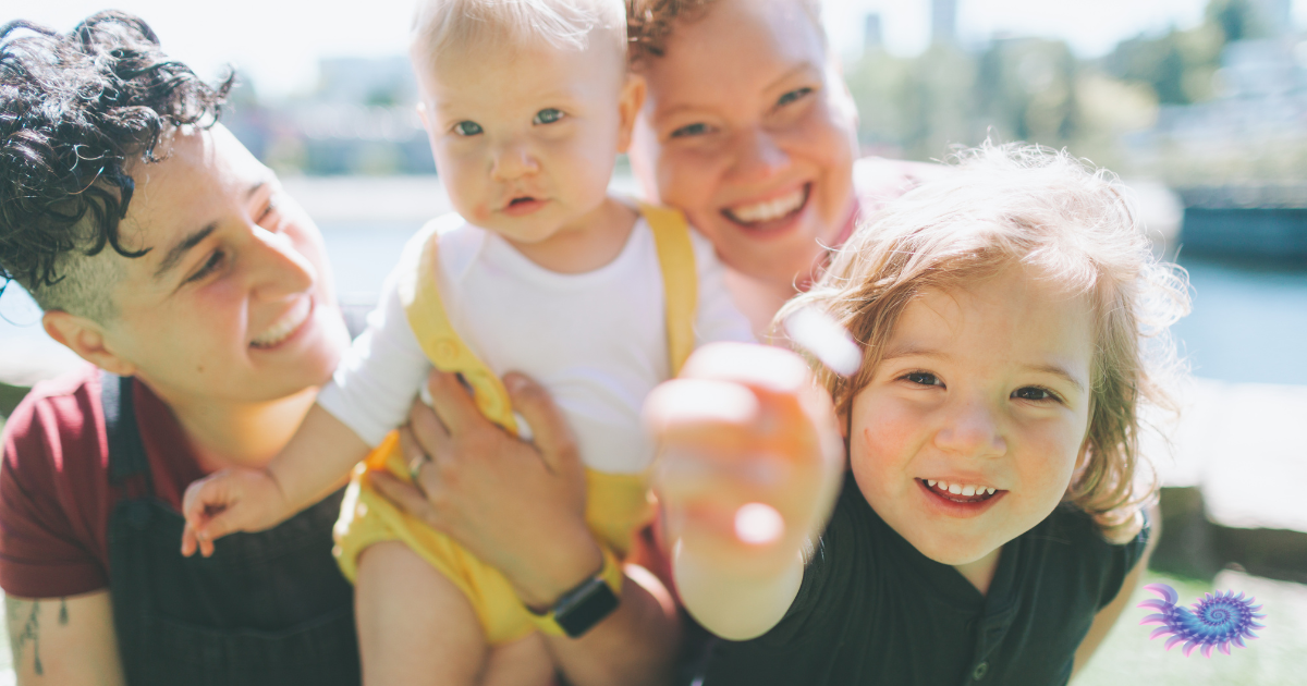 Happy LGBTQ family frolicking in a sunny city street