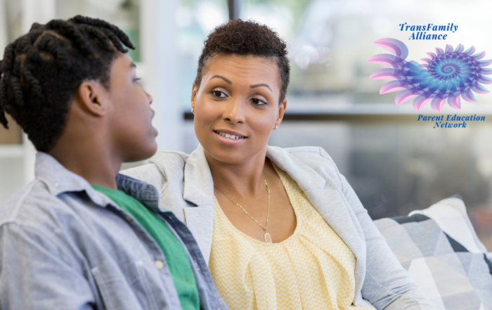 Parent sitting side-by-side with youth, presumably her child, having a conversation about the decisions to be made for the youth's gender affirming care