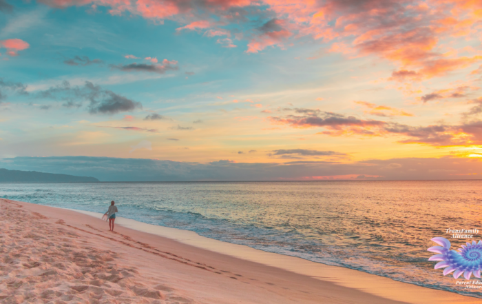 Figure walking along the ocean shore, practicing self-care for parents of trans and nonbinary kids in the most photogenic way possible