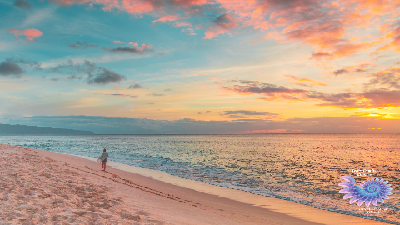 Figure walking along the ocean shore, practicing self-care for parents of trans and nonbinary kids in the most photogenic way possible